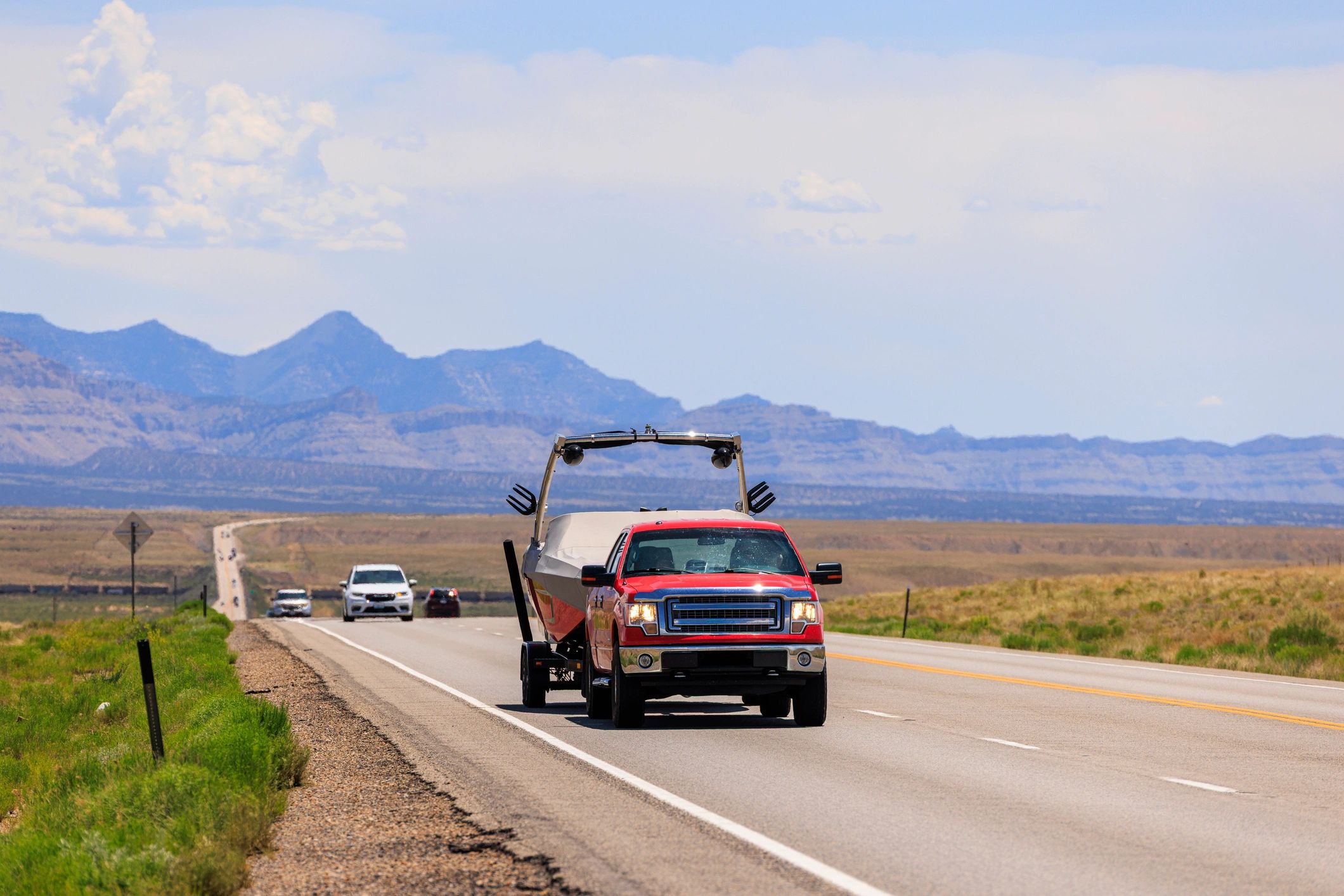 Red pickup truck traveling through desert terrain