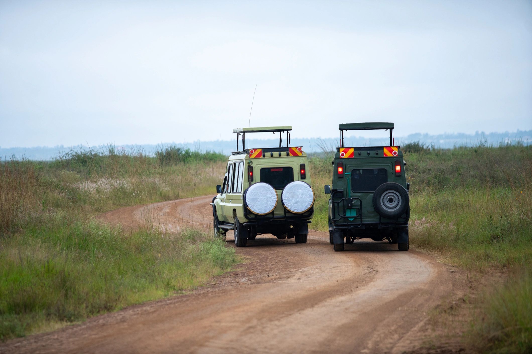 Two four-wheel-drive vehicles on a dirt trail